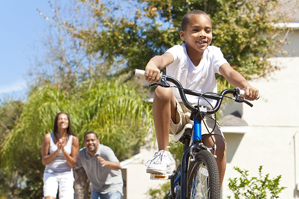 Biking child with cheering parents