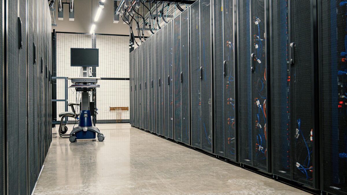 Modern data center corridor with server racks and computer equipment.