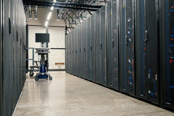 Modern data center corridor with server racks and computer equipment.